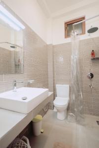 a bathroom with a white sink and a toilet at Negombo 146 Homestay in Negombo