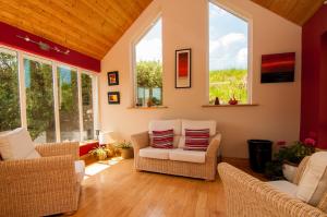 a living room with chairs and windows at Pairc Lodge in Doolin