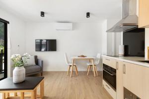 a kitchen and living room with a couch and a table at Skyline Suite in Queenstown