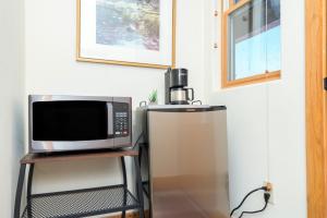 a microwave sitting on a stand next to a refrigerator at Bear Creek Lodge 309C Hotel Room in Telluride