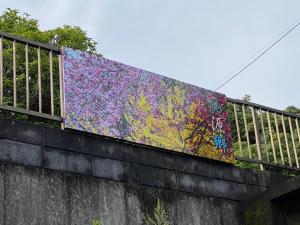 Hotel Ryokan Togenkyo - Vacation STAY 97146v في إيسي: جدار مغطى بالرسومات فوق جسر