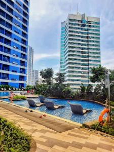 a swimming pool with lounge chairs in a city at Stylish&Comfort Unit in Air Makati by Luca's Cove in Manila