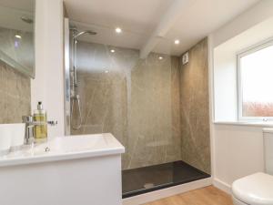 a bathroom with a shower and a sink and a toilet at Stable Cottage in Whitby +36 photos