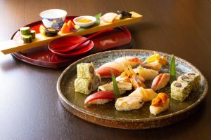 a plate of food with sushi on a table at ANA Crowne Plaza Resort Appi Kogen, an IHG Hotel in Hachimantai