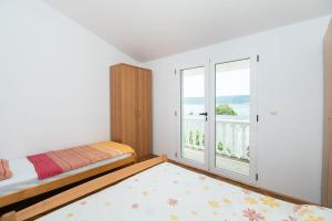 a bedroom with a bed and a balcony at Apartments More Sunce in Seline