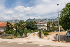 a house on a street with mountains in the background at Apartments More Sunce in Seline