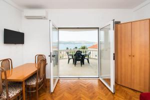 a dining room with a table and a sliding glass door at Apartments More Sunce in Seline