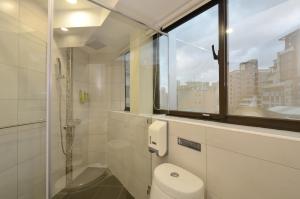 ein Bad mit einem WC und einem Fenster in der Unterkunft Hua Da Hotel- Nanxi in Taipeh