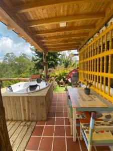 eine Terrasse mit einer Badewanne, einem Tisch und einem Boot in der Unterkunft Bio Cabaña Maria Guadalupe in Rionegro