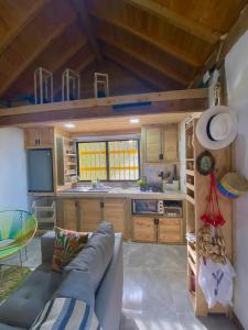 ein Wohnzimmer mit einem Sofa und einer Küche in der Unterkunft Bio Cabaña Maria Guadalupe in Rionegro