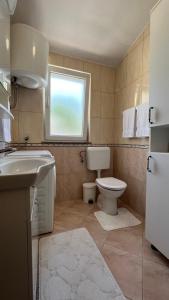 a bathroom with a toilet and a sink and a window at House Roca in Vodice +25 photos