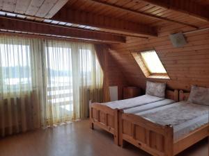 una camera con due letti in una casa di legno di Antal Villa - 5mins to ski slope & 1min to skating a Harghita-Băi