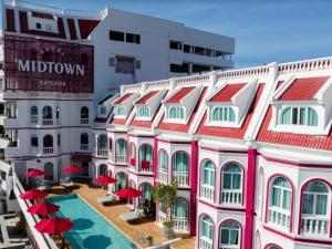 a building with red roofs and a swimming pool at Hotel Midtown Ratsada in Phuket