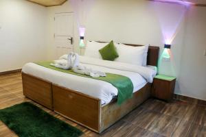 a bedroom with a large bed with two swans on it at Jakhu Vibes in Shimla
