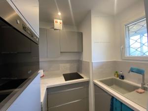 małą kuchnię ze zlewem i kuchenką mikrofalową w obiekcie Appartement rénové en front de mer avec terrasse. - FR-1-100-295 w mieście Cavalaire-sur-Mer +10 zdjęć