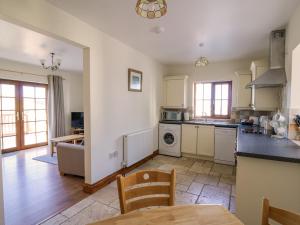 eine Küche und ein Wohnzimmer mit Tisch und Stühlen in der Unterkunft Beudy in Cardigan + 12 Fotos