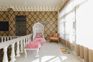 ein Raum mit einer Treppe mit einem Stuhl und einem Spiegel in der Unterkunft RedDoorz Plus @ Villa Bontes Batu in Batu