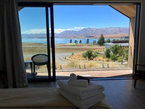 a room with a large window with a view of a lake at The Quarters Unit 1 - Lake Tekapo in Lake Tekapo