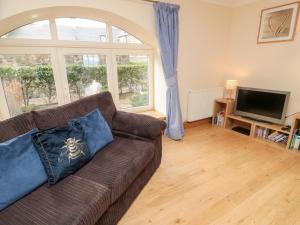 ein Wohnzimmer mit Sofa und Fernseher in der Unterkunft Low Croft in Alnwick