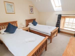 a bedroom with two beds and a window at Low Croft in Alnwick