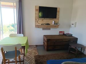 salon ze stołem i telewizorem na ścianie w obiekcie Domaine Decotte bungalow w mieście Sainte-Suzanne