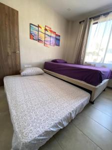 two twin beds in a room with a window at Departamento Playas Villamil vacaciones in Playas