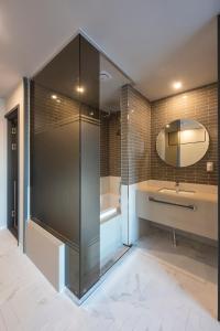 a bathroom with a shower and a sink and a mirror at Browndot hotel Guseo in Busan