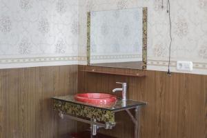 ein Badezimmer mit einem roten Waschbecken und einem Spiegel in der Unterkunft RedDoorz Plus @ Villa Bontes Batu in Batu + 80 Fotos