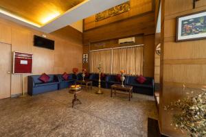 una sala d'attesa con divani blu e un tavolo di Hotel Tamizh Park a Pondicherry