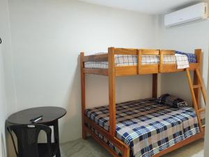 Litera en habitación con mesa y taburete en Kánela Hotel - Cabañas en Pedernales