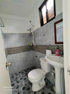een badkamer met een toilet en een wastafel bij Hotel Oasis Port Barton in San Vicente