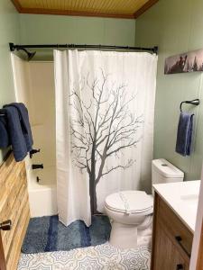 a bathroom with a shower curtain with a tree on it at Pet friendly cabin on 5 Acres near Boone & parkway in Triplett