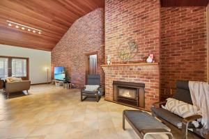 a living room with a brick wall and a fireplace at The Fletcher Estate in Nulkaba