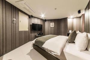 a bedroom with a bed and a flat screen tv at Jbis Hotel in Uijeongbu