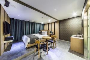 ein Hotelzimmer mit einem Bett, einem Tisch und Stühlen in der Unterkunft Jbis Hotel in Uijeongbu