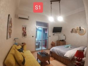 1 dormitorio con cama, sofá y TV en Ryan S1et Ryan S2 en Fez