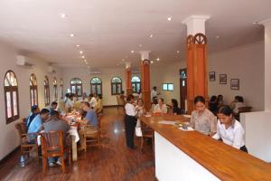 a group of people sitting at tables in a restaurant at Sunset INN by Pro-Ema in Dili
