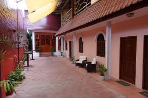 un patio de una casa con sillas y mesas en Sunset INN by Pro-Ema, en Dili