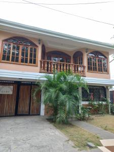 a house with a palm tree in front of it at Casa MONTOCO 114 in Managua