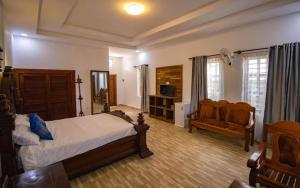 1 dormitorio con 1 cama y 1 sofá en Kampheak Roath Bungalows, en Kampot