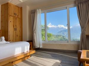1 dormitorio con ventana grande con vistas a la montaña en Hotel Pokharaeye, en Pokhara