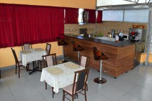 un restaurante con 2 mesas y una cocina con cortinas rojas en Qori Arequipa, en Arequipa