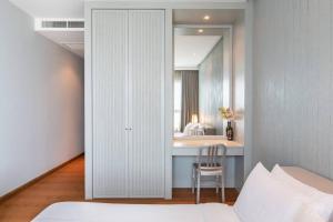 a bedroom with a mirror and a bed and a chair at Ocean Portofino/Luxury2BR/153SQM in Na Jomtien
