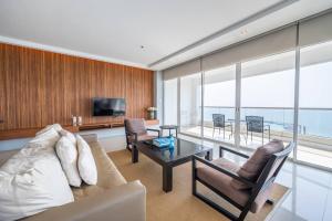 a living room with a couch and a table at Ocean Portofino/Luxury2BR/153SQM in Na Jomtien
