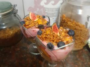 two glasses filled with fruit and granola on a table at DOTJJ B & B in Paarl