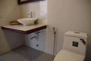 a small bathroom with a sink and a toilet at Kampheak Roath Bungalows in Kampot