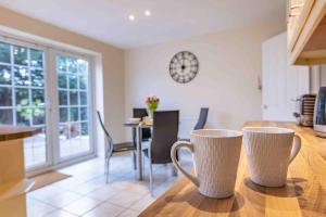 two coffee cups sitting on a table in a kitchen at Spacious house in quiet cul-de-sac near to Hospital in Shrewsbury +42 photos