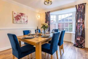 a dining room with a wooden table and blue chairs at Spacious 5 bedroom house in quiet cul-de-sac in Shrewsbury