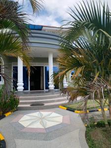un bâtiment avec des palmiers en face de celui-ci dans l'établissement Ishuro Villas, à Rukungiri