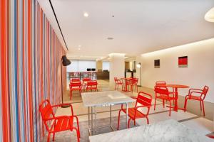 a dining room with red chairs and a table at Hotel Midcity Myeongdong in Seoul